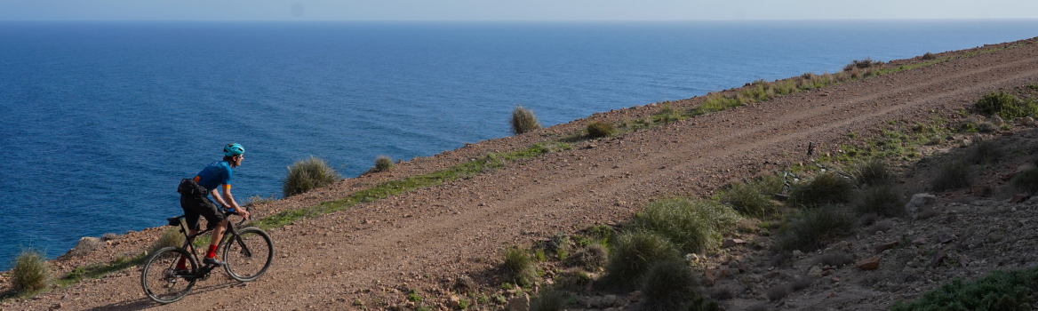 Hombre en bicicleta gravel por una pista en dirección al Cabo de Gata.