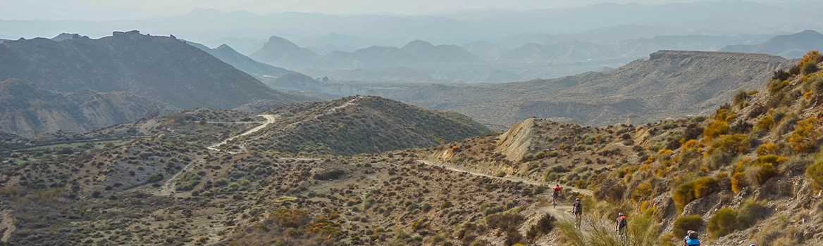 Grupo de ciclistas de gravel en una estrecha pista en el desierto de Tabernas