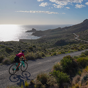 Una mujer en bicicleta por una pista que domina el mar Mediterráneo en Andalucía, en dirección al Cabo de Gata