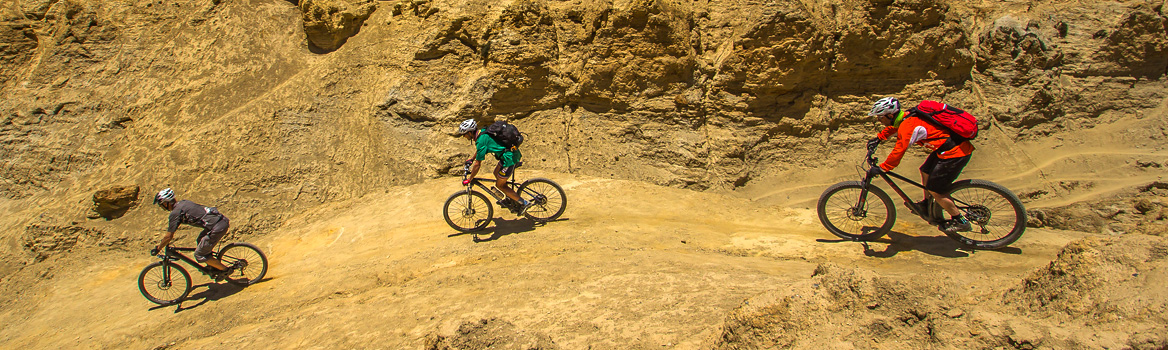 3 ciclistas de montaña montando en un entorno mineral