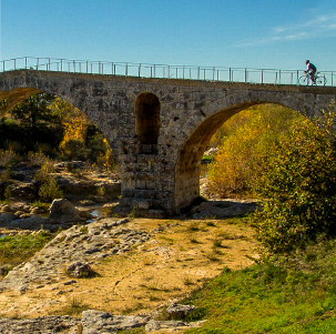 Ciclista de carretera en un puente de piedra