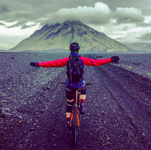 Ciclista de montaña en climax frente a un volcán en Islandia